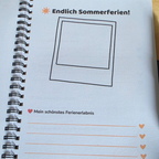 Aufgeschlagenes Erinnerungsbuch zur Einschulung mit farbig gestalteter Ausfüllseite, Platz für ein Erinnerungsfoto und Zeilen für eigene Notizen.