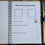 Aufgeschlagenes Erinnerungsbuch zur Einschulung mit farbig gestalteter Ausfüllseite, Platz für ein Erinnerungsfoto und Zeilen für eigene Notizen.