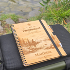 Personalisiertes Fangjournal aus Holz auf einer Angeltasche am See