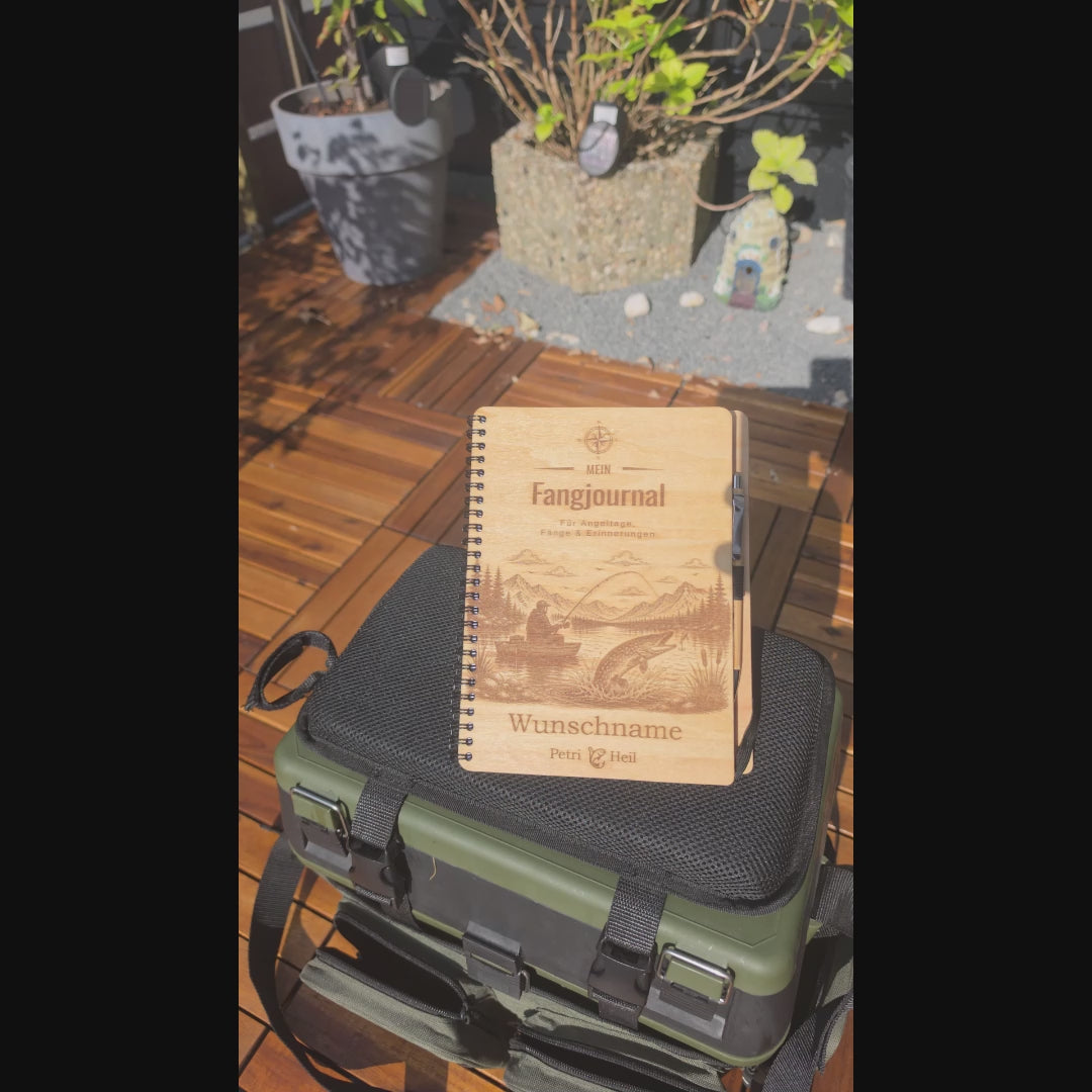 Produktvideo eines personalisierten Fangjournals aus Holz: Eine Hand blättert das Buch mit Ringbindung auf und zeigt die gravierte Holz-Vorderseite, den mitgelieferten Bambus-Kugelschreiber sowie die gestalteten Innenseiten für persönliche Daten und Angel-Steckbriefe.