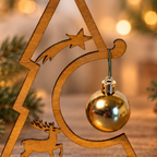 Detailaufnahme des Holz-Weihnachtsbaums mit Rentier, Sternschnuppe und Aufhängung der goldenen Weihnachtskugel.